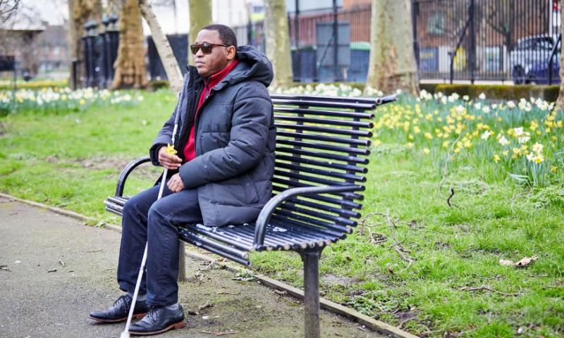 Image of man sitting on a bench in the park